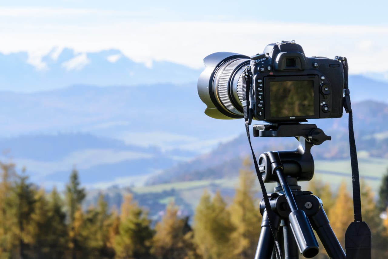 our-stories DSLR camera on tripod capturing a stunning mountain view on a clear day.